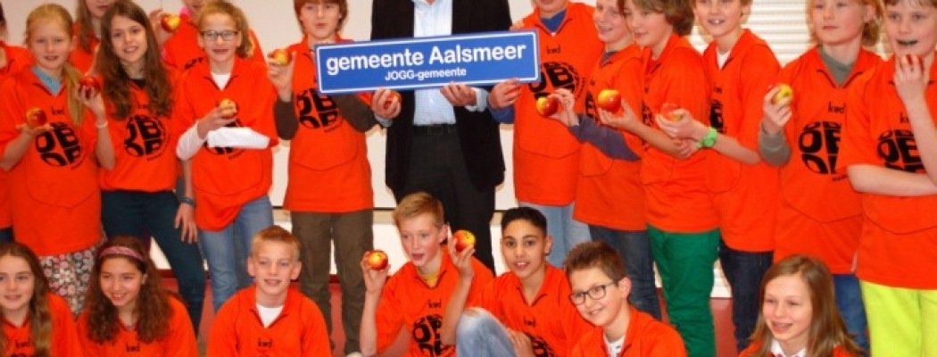 Wethouder Zorg en Welzijn Ad Verburg geeft het startsein van de aanpak Jongeren op Gezond Gewicht (JOGG) met het uitdelen van appels aan kinderen van groep 8 van O.B.S. Kudelstaart.