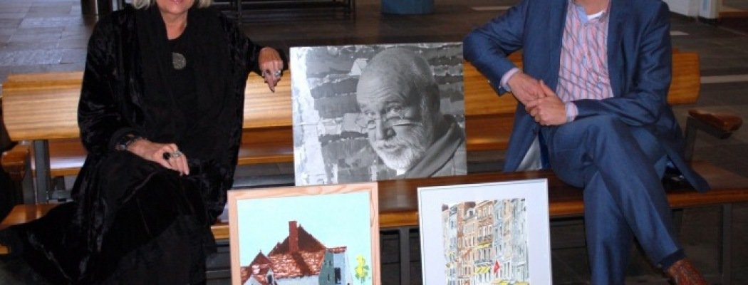 Janna van Zon en Gertjan van der Hoeven bij een foto en schilderijen van Jan Faber