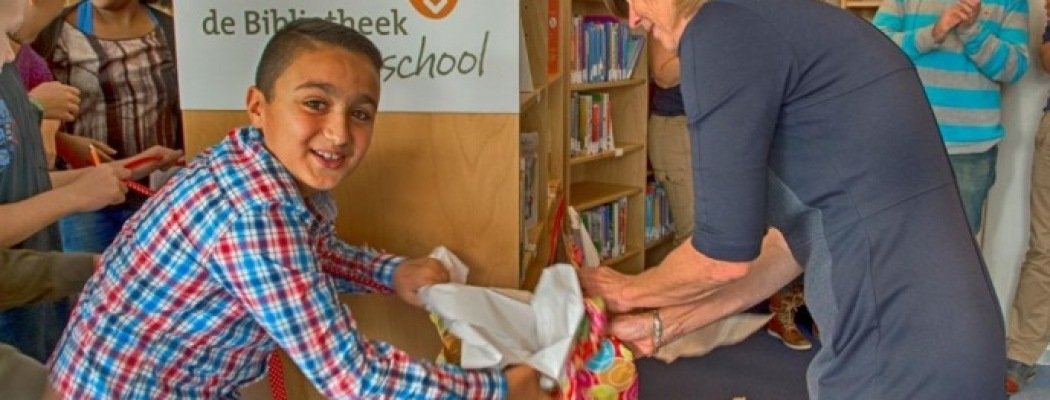 Ria Zijlstra pakt samen met leerlingen de eerst Bibliotheek op school boekenkast uit