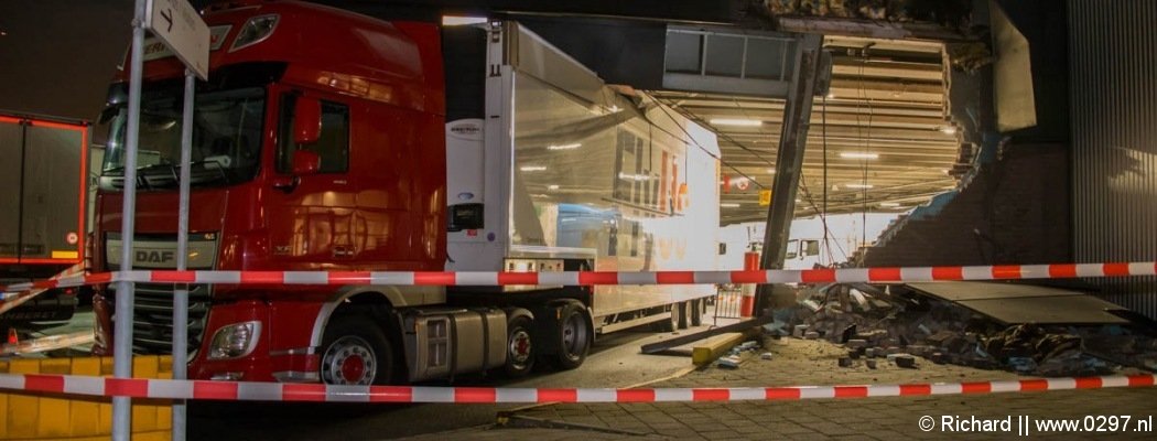 Vrachtwagen rijdt gevel bloemenveiling Aalsmeer er uit