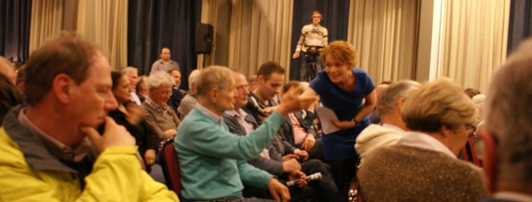 Debatleider Elisabeth van den Hoogen laat een bezoeker aan het woord tijdens verkiezingsdebat.