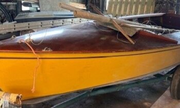 Gele houten zeilboot